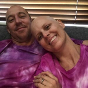 image of husband supporting wife with lymphoma cuddling on lounge